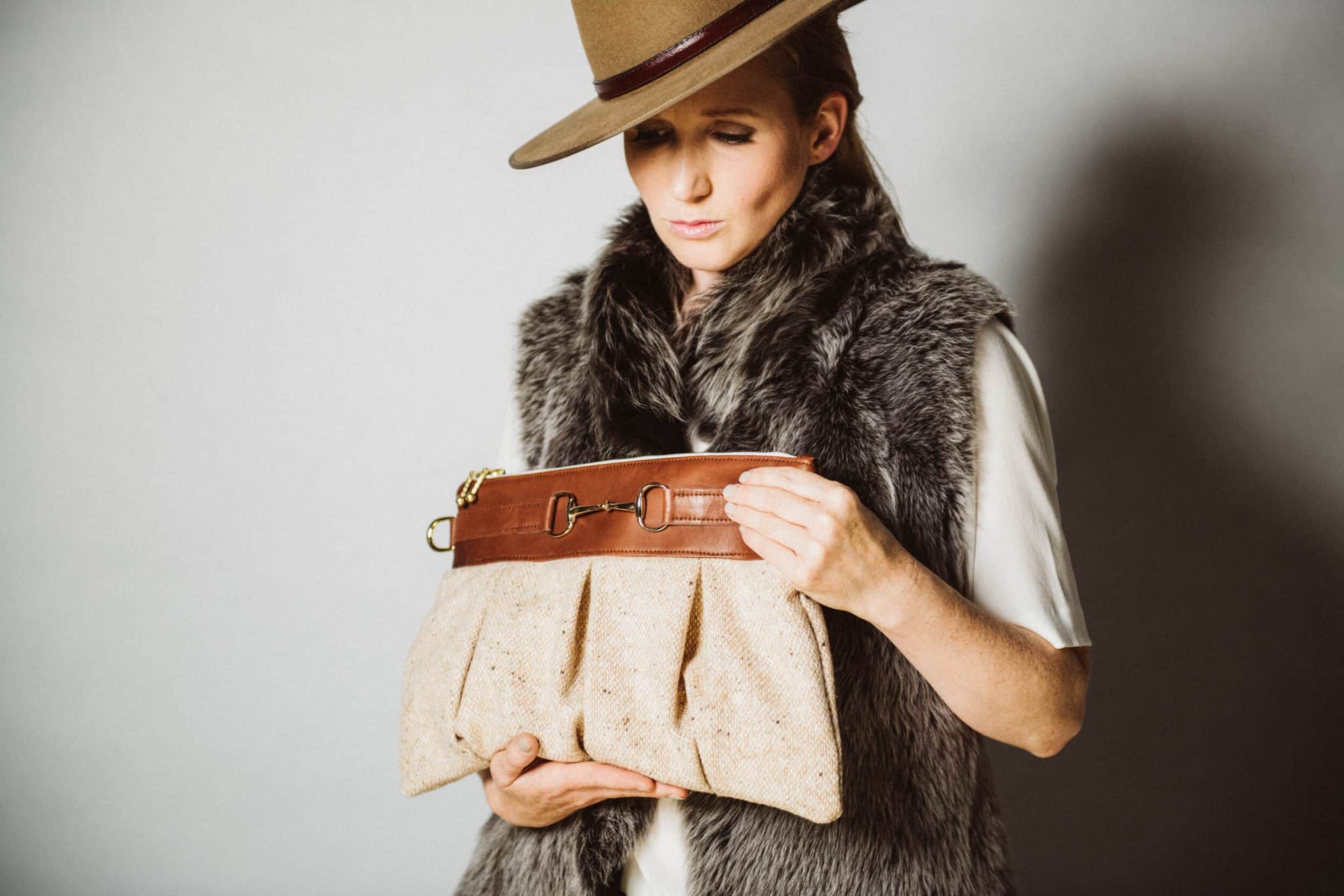 Produktfotografie Frau mit Tasche guckt nach unten im Fotostudio von Miriam Merkel