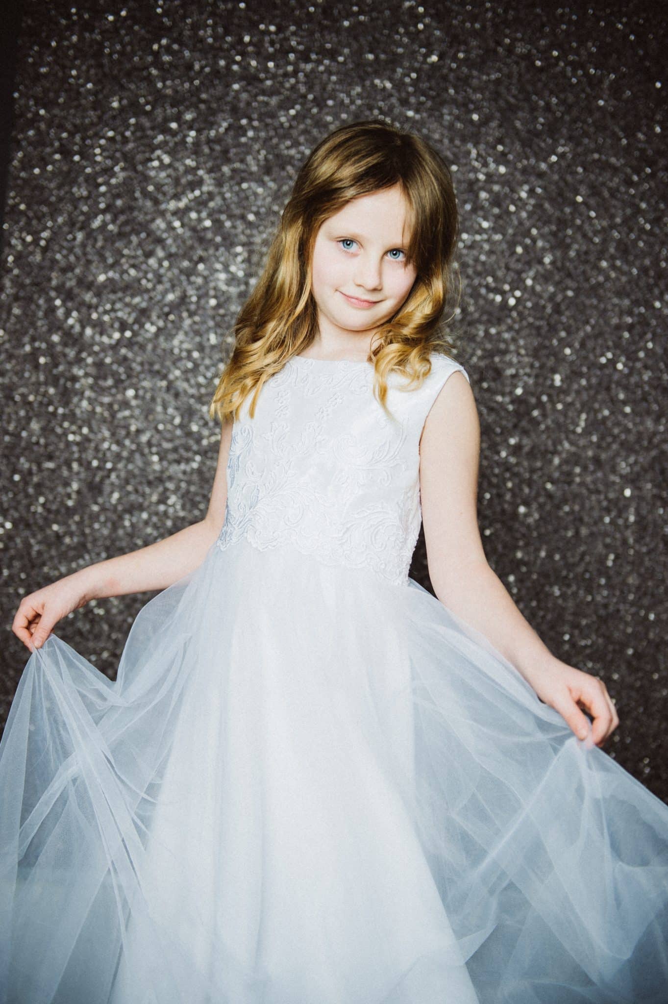 Kommunionsfoto – Konfirmationsfoto – Kinderportraits by Miriam Merkel Fotografie Mädchen Portrait vor grauem Glitzerhintergrund Kommunion Firmung Konfirmation