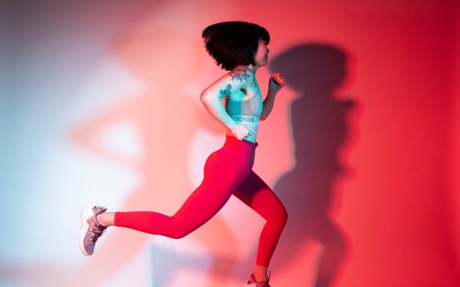 Sport Fotografie Frau im Sportanzug joggt nach rechts im Fotostudio von Miriam Merkel