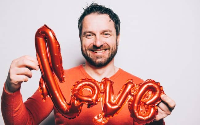 Mann mit Love Ballon Schriftzug Valentinstag