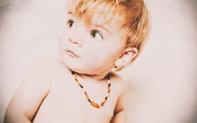 Portraitfoto kleiner blonder Junge mit Bernsteinkette