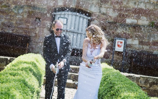 Hochzeitsfotografie Nörten Hardenberg Brautpaar öffnet Champagne Flaschen