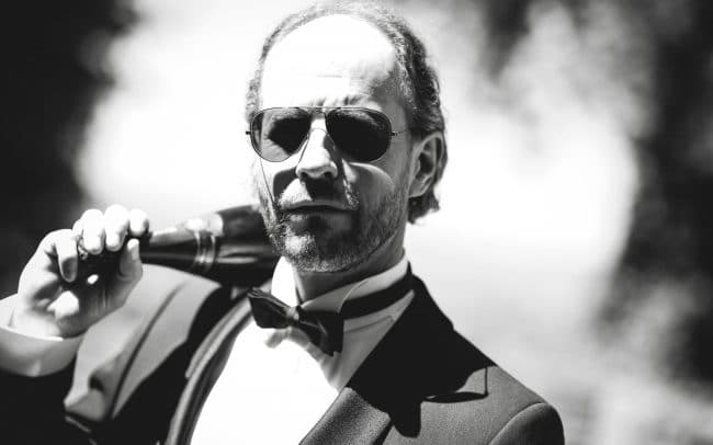 Hochzeitsfotografie Nörten Hardenberg Bräutigam trägt Champagne in Schwarz/Weiss
