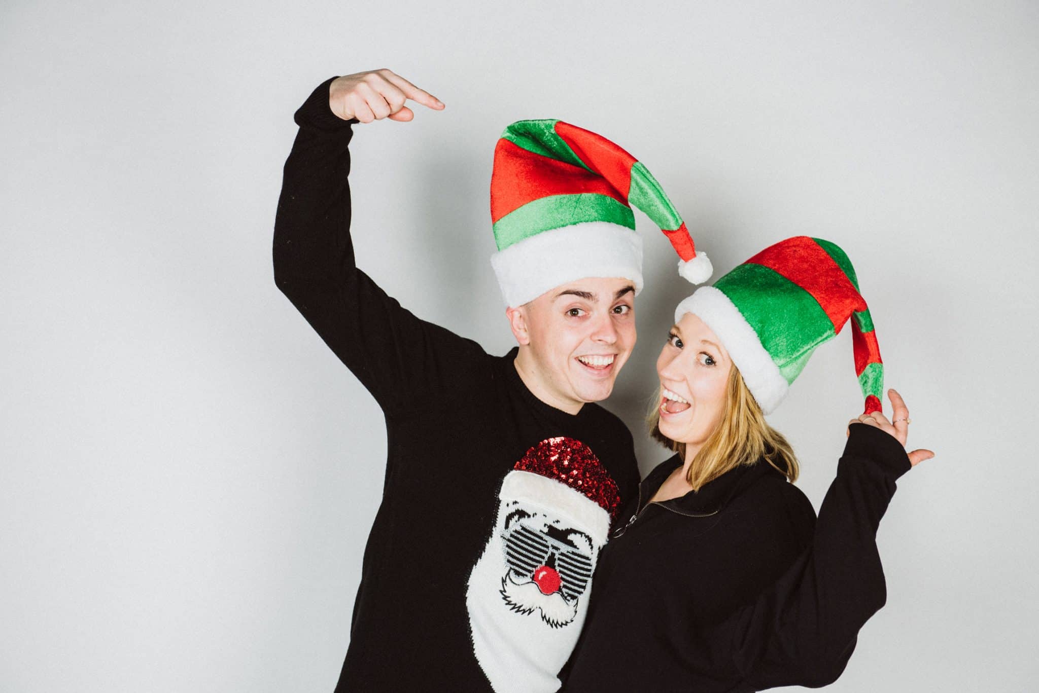 Weihnachten Christmas Weihnachtsfotografie Miriam Merkel Fotografie Paarportrait mit Weihnachtswichtel MĂĽtzen lachend im Studio von Miriam Merkel